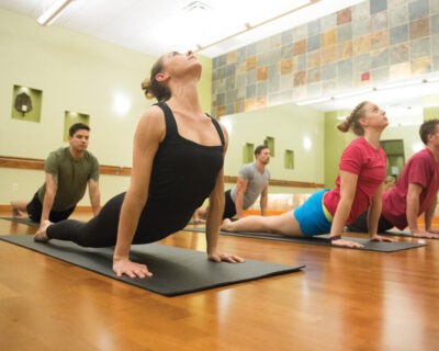 A Group at Yoga Class in Upward Facing Dog Pose at Wellbridge Athletic Club in Denver, CO