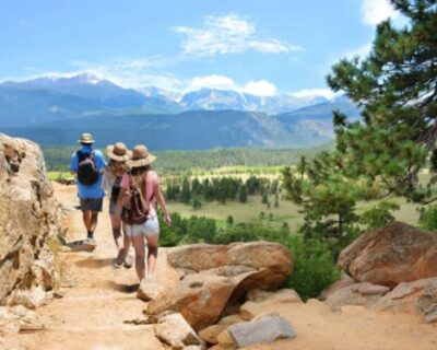 Three Hikers Ascend a Rocky Mountain Trail in CO