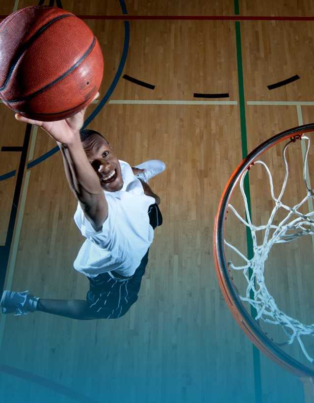 A man playing basketball on a court in Colorado Athletic Club