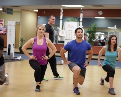 Man & Woman holding a lunge | Group Fitness Classes | Del Norte Sports & Wellness | Albuquerque, NM
