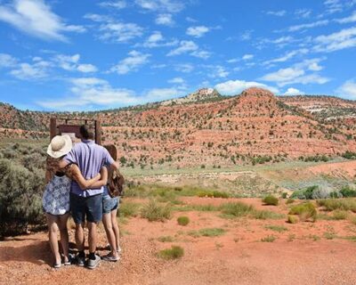 A family stands together on a red dirt road during a group hike in Albuquerque, NM