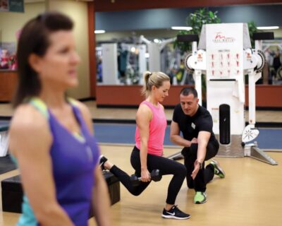 A man and woman engaged in squats at a gym highlighting training programs in Albuquerque, NM