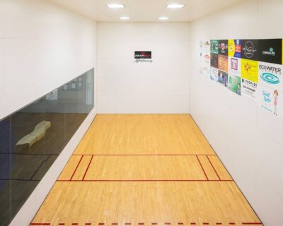 A squash court featuring a polished wooden floor and a solid wall in Albuquerque, NM