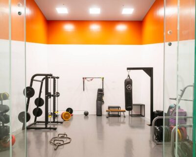 An orange and white gym room featuring various fitness equipment in Albuquerque, NM