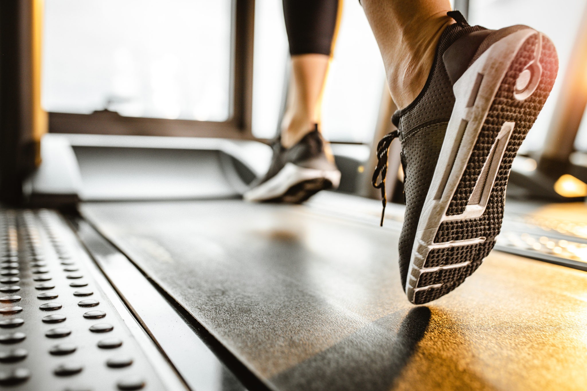 Close up of athlete running on a treadmill in a gym.