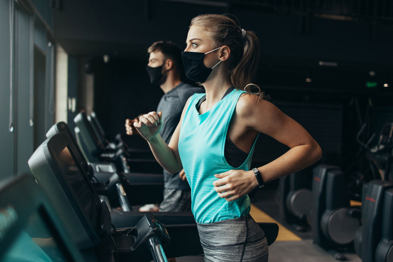 woman running on treadmill with mask