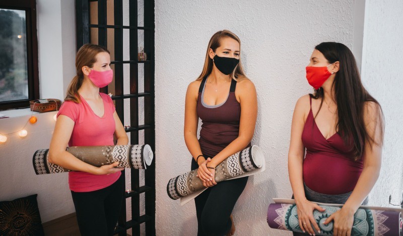 Women with yoga mats in a fitness studio at Wellbridge