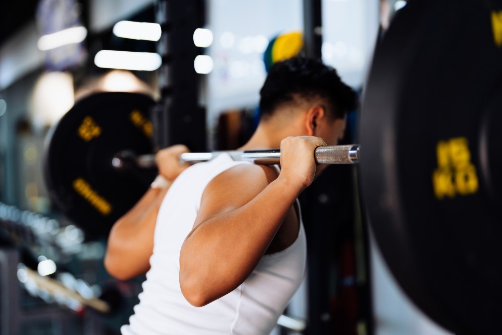 Man lifting at the gym after taking creatine supplements.